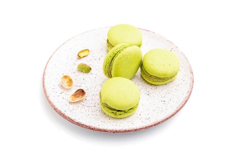 Green macarons or macaroons cakes isolated on white background. Side view, close up