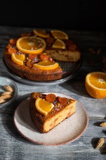 Orange cake on a gray wooden background. Hard light. contrast, low key. Side view, close up
