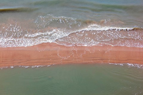 Aerial view at sea waves rolling in to a sand beach, Skagen, Denmark, Europe