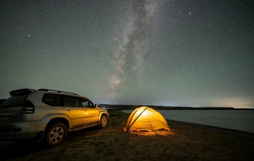 Off-road vehicle and tent, night shot, Milky Way at Lake Issyk Kul, Kyrgyzstan, Asia