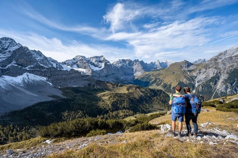 Two mountaineers, on a hiking trail, friendship on the mountain, mountain panorama with rocky steep