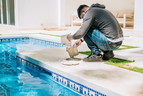 Man cleaning swimming pool garbage filter. Worker removing trash from swimming pool filter basket