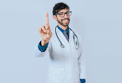 Doctor counting number ONE isolated. Handsome doctor counting number 1 on isolated background.