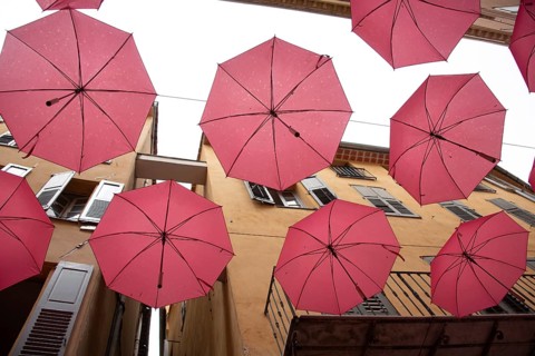 In the perfume town of Grasse, red umbrellas hang between the houses, Grasse, Provence-Alpes-Côte