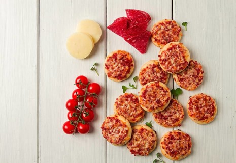 Mini pizzas, salami with mozzarella cheese, on a white table, top view, no people