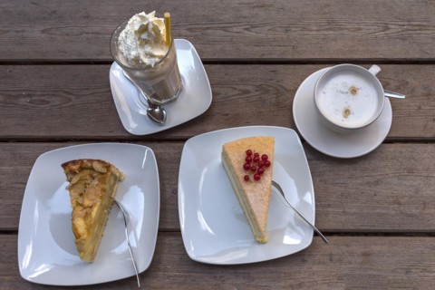 Cake and iced coffee with cream and cappuccino on a wooden table, Mecklenburg-Vorpommern, Germany,