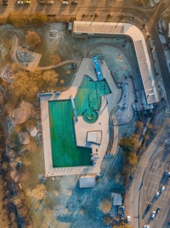 Drone image of an outdoor pool during twilight hours in an urban environment with frozen water ENCW