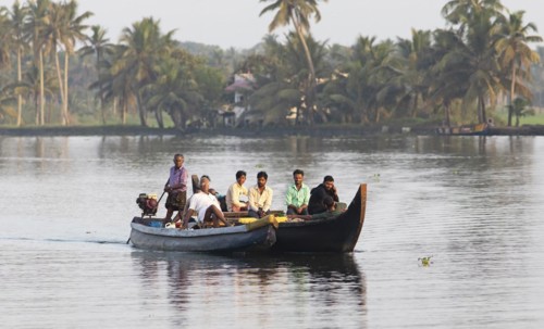Indian men travelling on a motorboat, canal system of the backwaters, Kerala, India, Asia
