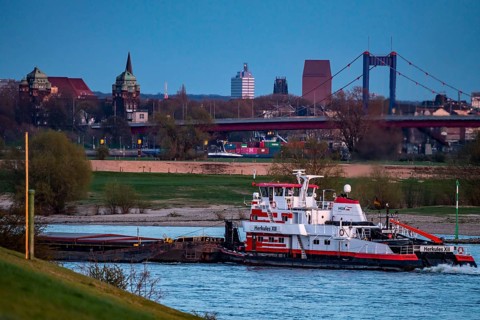 Cargo ship on the Rhine near Duisburg-Beeckerwerth, skyline of the city centre, with town hall,