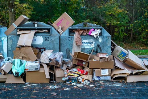 Overfilled waste paper containers, despite the overcrowding, people have put their waste paper next