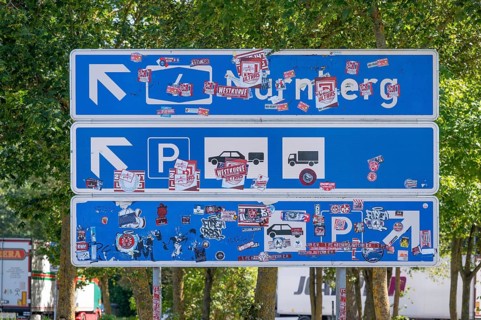 Motorway sign covered with stickers at a motorway service area, A6 motorway, Baden-Württemberg,