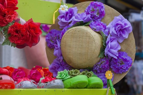 Straw hat decorated with artificial flowers in red and purple, Ile de Brehat, Brittany, France,