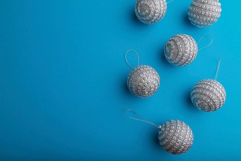 Christmas or New Year composition. Decorations, silver balls, on a blue paper background. Top view,