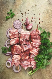 Raw pork meat, on wooden skewers, pickled kebab, with spices and herbs, on the table, top view, no
