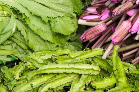 Purple lotus flowers and a green salad on the market