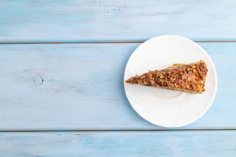 Walnut and hazelnut cake with caramel cream on blue wooden background. top view, flat lay, copy