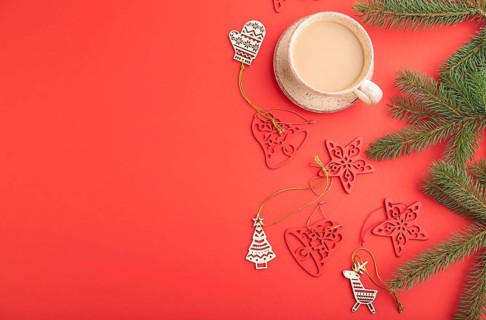 Christmas or New Year composition. Decorations, fir and spruce branches, cup of coffee, on a red
