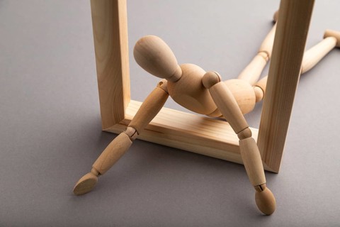 Wooden mannequin crawl out of a wooden frame on gray pastel background. escape, break rules,