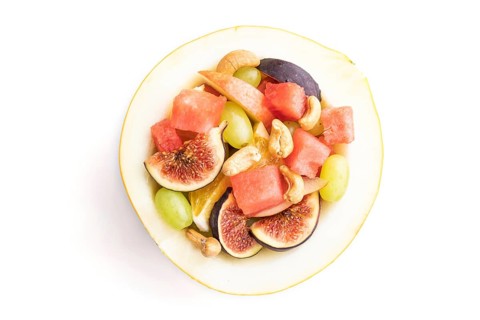 Vegetarian fruit salad of watermelon, grapes, figs, pear, orange, cashew isolated on white