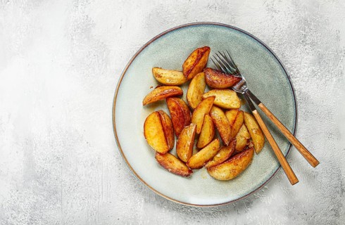 Fried potato slices, on a plate, top view, homemade, no people