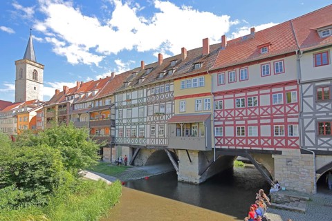 Famous Krämerbrücke and Gothic Ägidienkirche with river Gera and people sitting on the bank, idyll,