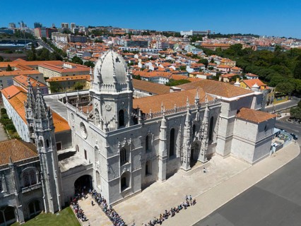 Gothic church with impressive tower and detailed façade in front of an urban landscape with