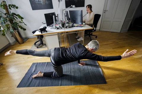 Symbolic photo on the subject of occupational health management. A woman exercises on a sports mat