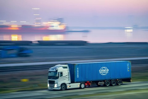 Lorry on the road to Euromax Terminal Rotterdam, ENECO wind farm on the dike around the port of