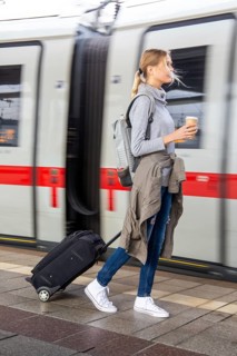 Young woman on the railway track while a train arrives