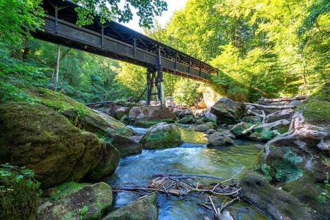 The Irrel Waterfalls, rapids in the lower reaches of the Prüm, covered wooden bridge for hikers,