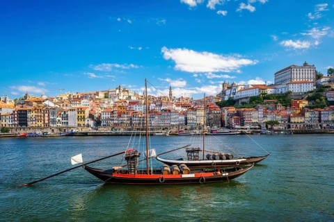 View of Porto city and Douro river with traditional boat with port wine barrels from famous tourist