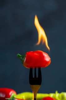 Burning red pepperoni on a fork, close-up, food photography