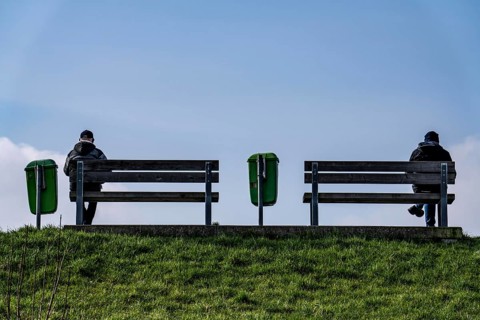 Benches on a dyke on the Weser in Bremerhaven, two people sitting symmetrically away from each