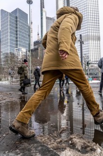 Winter in the city, Gallusanlage street, puddles, pools of water, melt water, pedestrians,