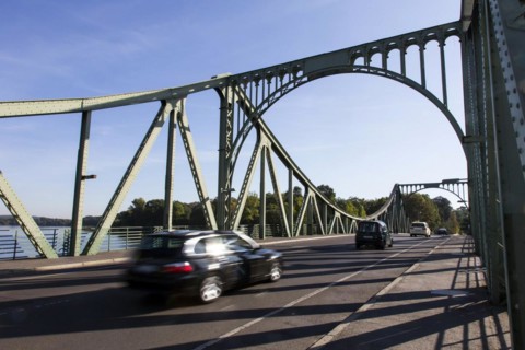 Cars drive over the Glienicke Bridge in Potsdam. The Glienicke Bridge today forms the city boundary