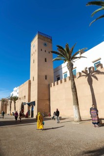People walking outside medina walls, L'Horloge d'Essaouira, Essaouira, Morocco, north Africa,