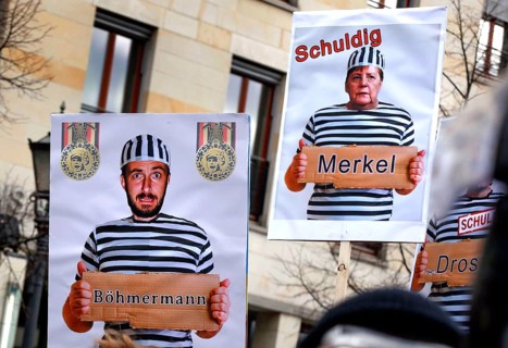 Posters show Chancellor Merkel and Jan Böhmermann in convict clothing. Once again, thousands of
