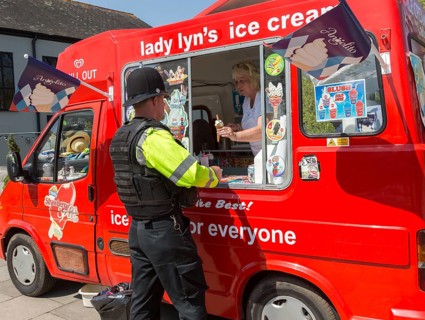 Policeman getting an ice-cream cone from an ice cream van, Salisbury, Wiltshire, England, UK