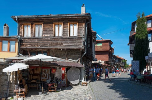 Street view with old wooden buildings, souvenirs and a lively street café on a sunny day, Black