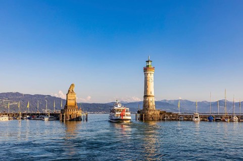 Bavarian Lion, an excursion boat and the lighthouse in the harbour, Lindau Island, Lindau, Lake