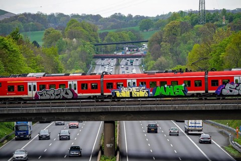 S-Bahn train crossing the motorway A3, traffic on 8 lanes, incl. the temporarily released hard