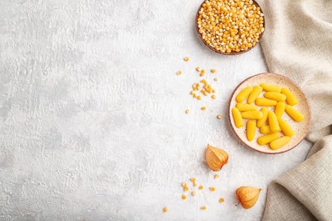Jelly corn candies on gray concrete background and linen textile. top view, flat lay, copy space