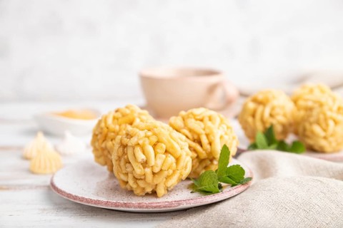 Traditional Tatar candy chak-chak made of dough and honey with cup of coffee on a white wooden