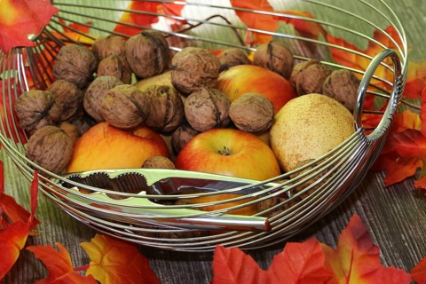 Apples, pears and walnuts on a rustic wooden table as an autumnal motif