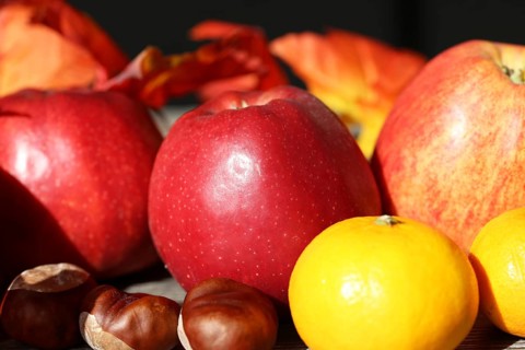 Apples and mandarins on a rustic wooden table as an autumnal motif