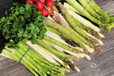 Green asparagus and white asparagus decorated on a rustic wooden table