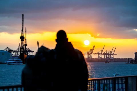 Port of Hamburg, couple looking at the Blohm + Voss shipyard, evening, cranes of the container