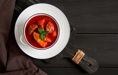 Stew with potatoes, in tomato sauce, with spices and herbs, close-up, no people, on a black