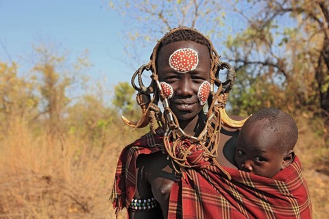 South Ethiopia, in Maco National Park, Mursi tribe, Mursi woman with baby, painted skin and
