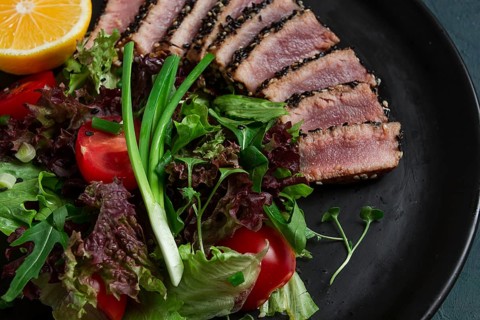 Vegetable salad, with fried tuna, in sesame seeds, healthy food, top view